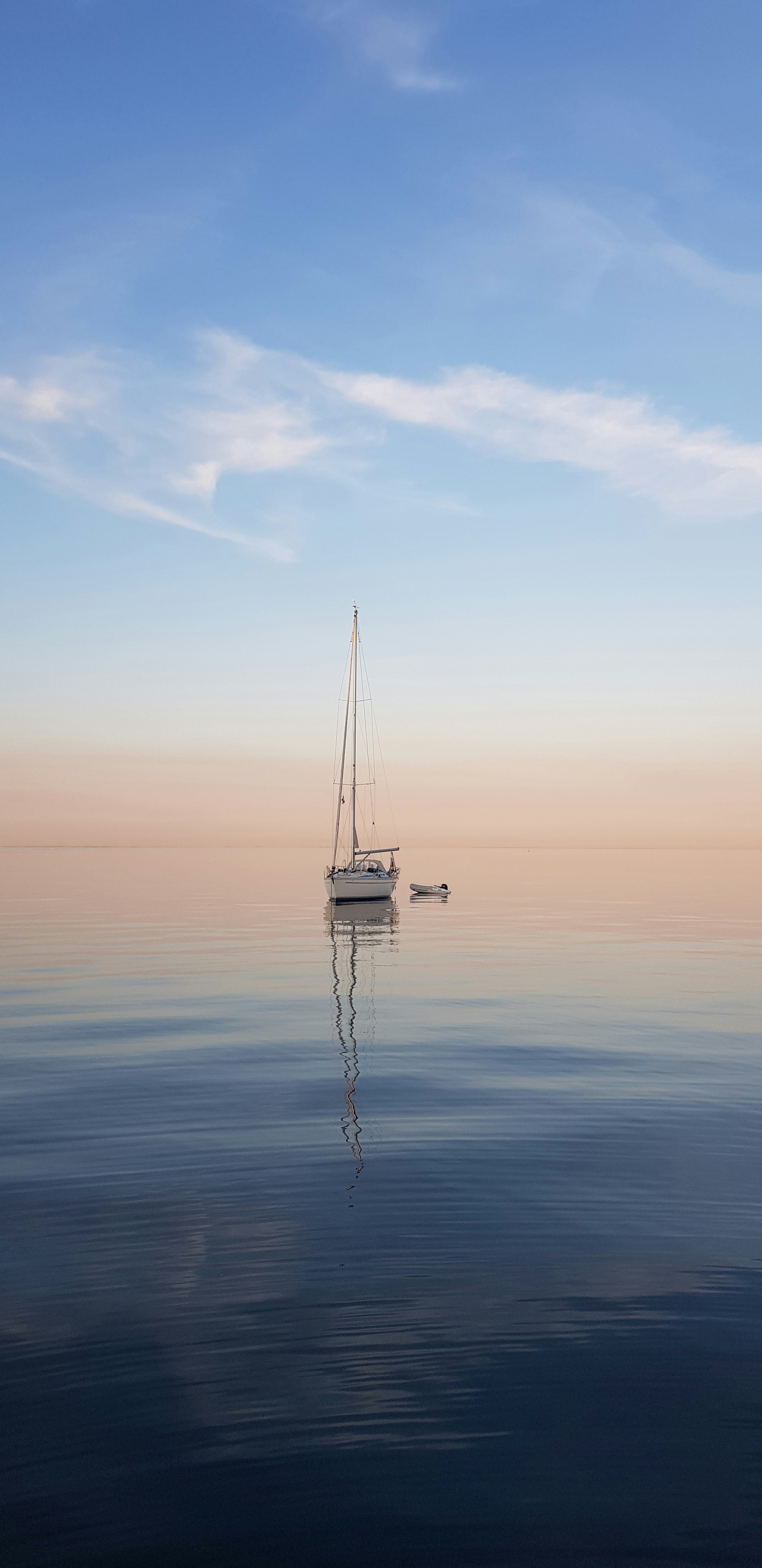 A becalmed sailboat at anchor