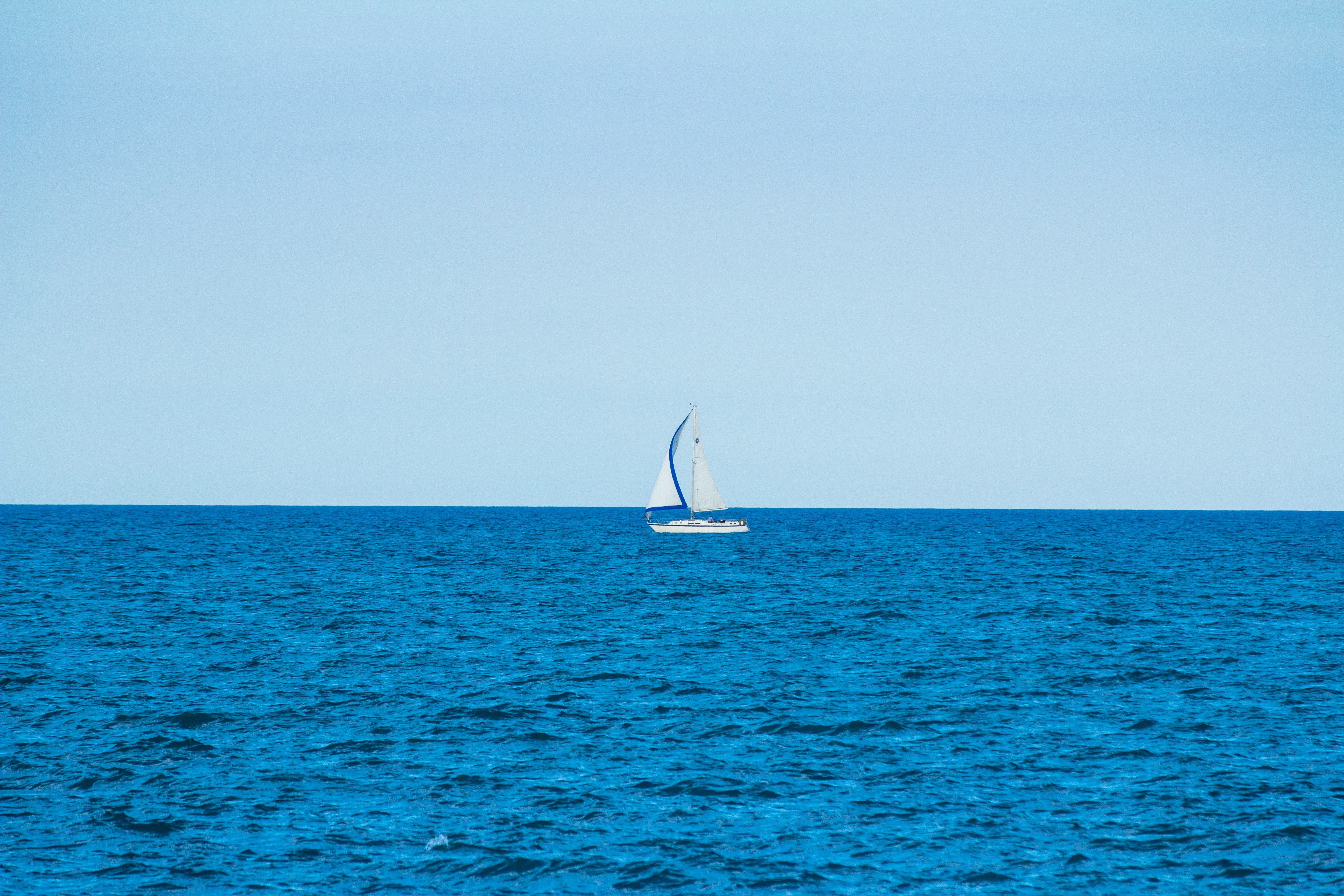 A small sailboat on open blue water